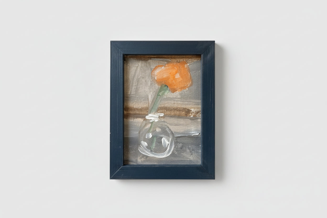 A framed oil painting on board depicting a still life with a flower in a vase, displayed against a wall with a shelf.